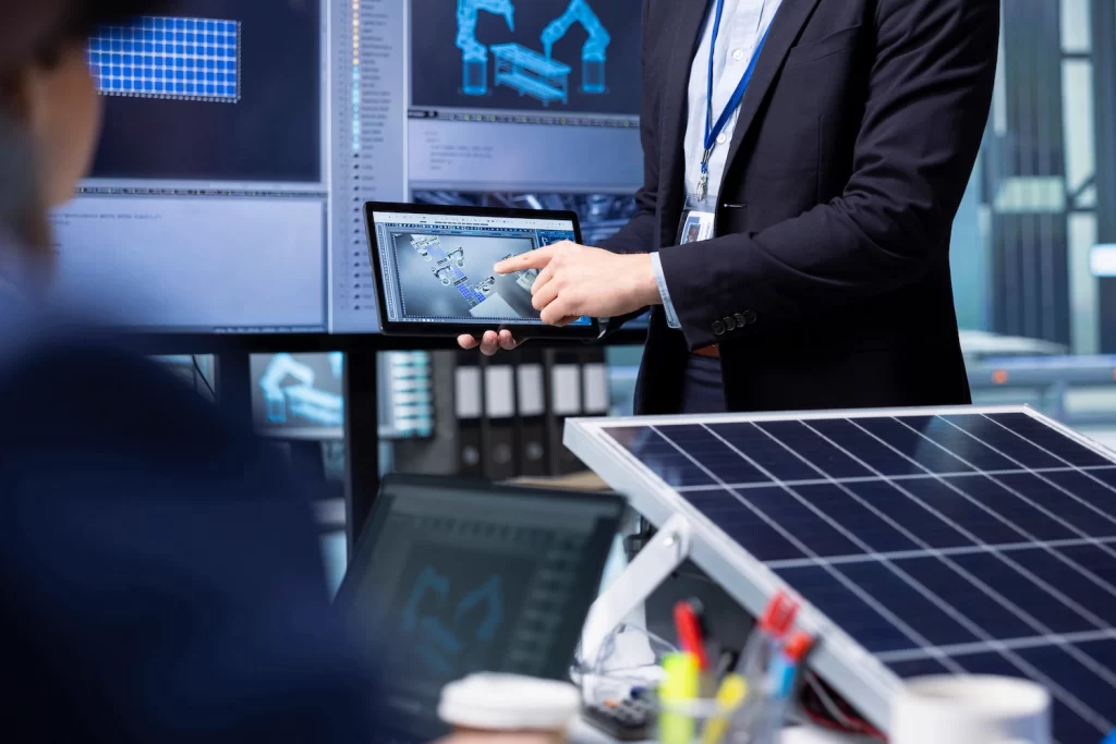 Investors examine solar panel surface using tablet discussing design efficiency.